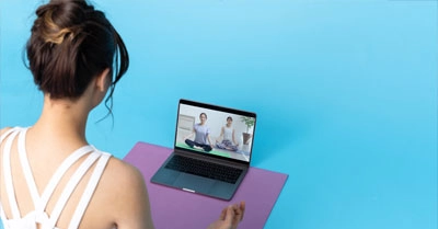 Yoga Übende mit Tablet nimmt an Online Yogakurs teil