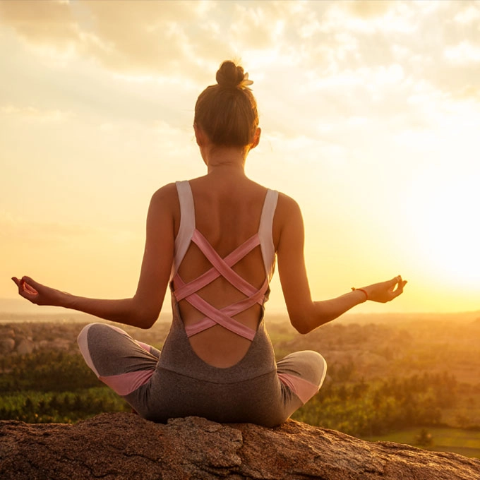 Yoga Sonnengruß am Morgen bei Sonnenaufgang – Frau praktiziert Morgengruß Yoga im Freien für einen energiegeladenen Start in den Tag.